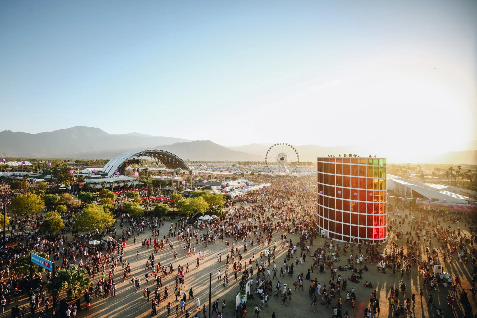 A vibrant crowd enjoying a live performance at Coachella 2024, with colorful stage lights in the background.