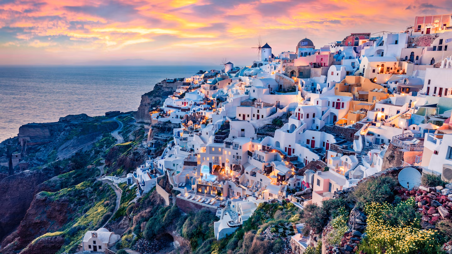 Panoramic view of Santorini's caldera with crystal-clear waters and steep hillsides.