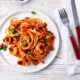 Sepiring spaghetti seafood dengan udang, cumi, dan kerang, disajikan dengan saus tomat yang kaya rasa dan aroma segar