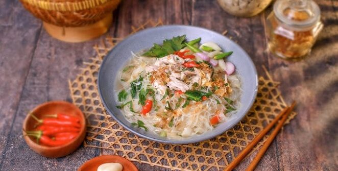 Bihun Kuah Ayam yang hangat, disajikan dengan kuah kaldu ayam bening dan irisan daun bawang serta seledri