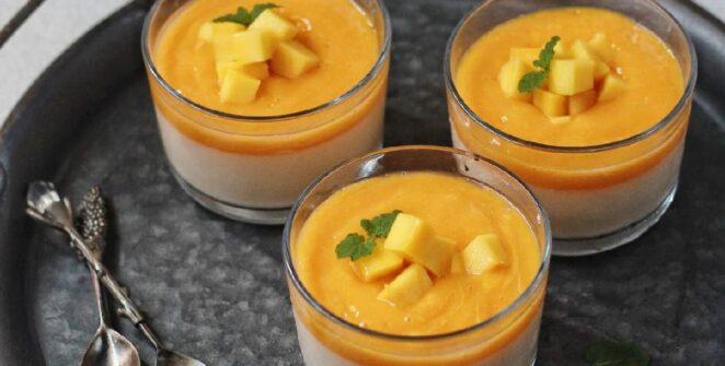 Puding mangga susu tersaji dalam gelas transparan, dihiasi dengan potongan mangga segar