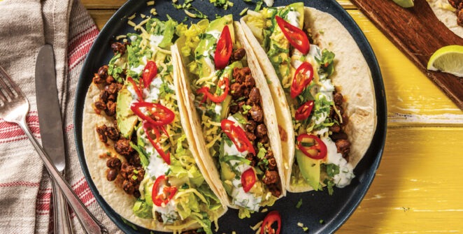 A colorful platter of Tacos Mexican Fiesta with marinated meats, fresh vegetables, and vibrant toppings